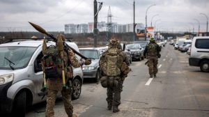 Ukrainian servicemen carry rocket-propelled grenades and sniper rifles as they walk towards the city of Irpin, northwest of Kyiv, Ukraine on March 13, 2022. (Dimitar Dilkoff/AFP via Getty Images)