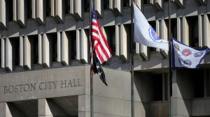 Flags fly above Boston City Hall on Nov. 11, 2021. (Photo by Lane Turner/The Boston Globe via Getty Images) (Lane Turner/The Boston Globe via Getty Images)