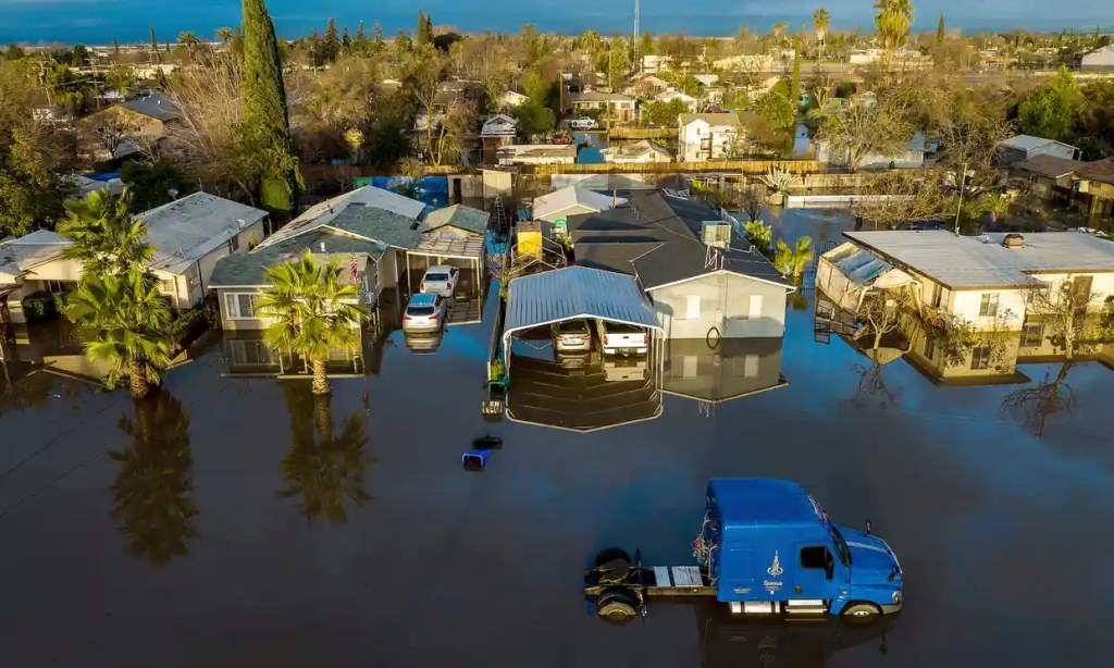 Following days of rain, floodwaters surround homes and vehicles in the Planada community of Merced County, California, on 10 January. Photograph: Noah Berger/AP
